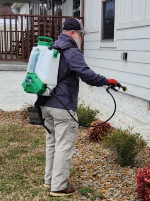 Critter Wranglers technician treating a home exterior
